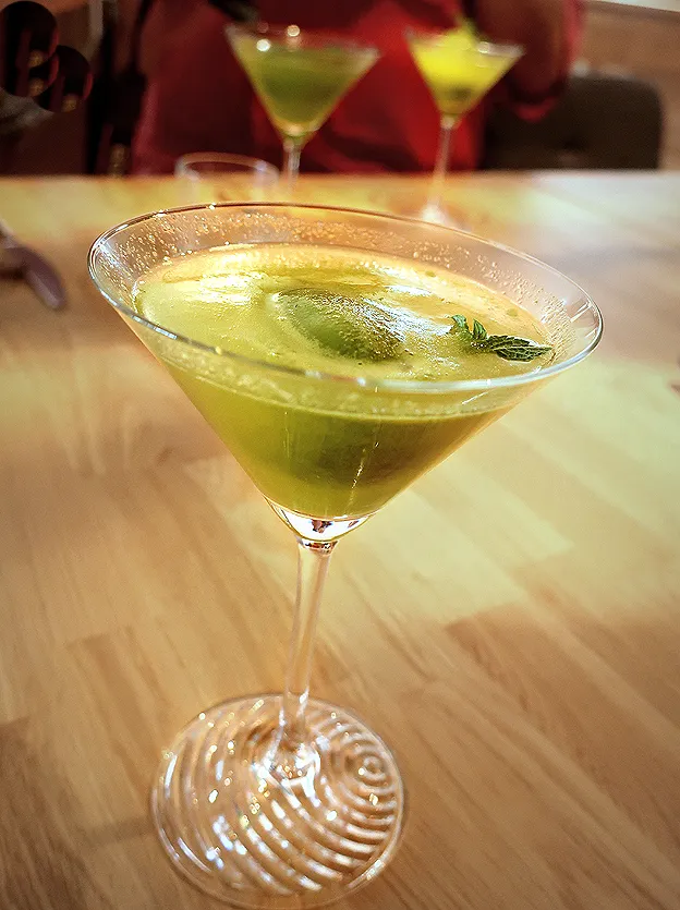 Ein erfrischender veganer Aperitif in der Hummelbude Essen, serviert in einem eleganten Glas, als Start des &quot;Weltverbesserung durch Genuss&quot;-Menüs.