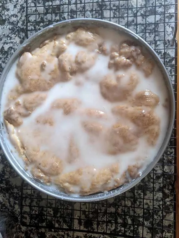 Ein fertig gebackener Gedeckter Apfelkuchen, der mit Zuckerguss überzogen ist und die perfekte Krönung für dieses traditionelle deutsche Dessert darstellt.