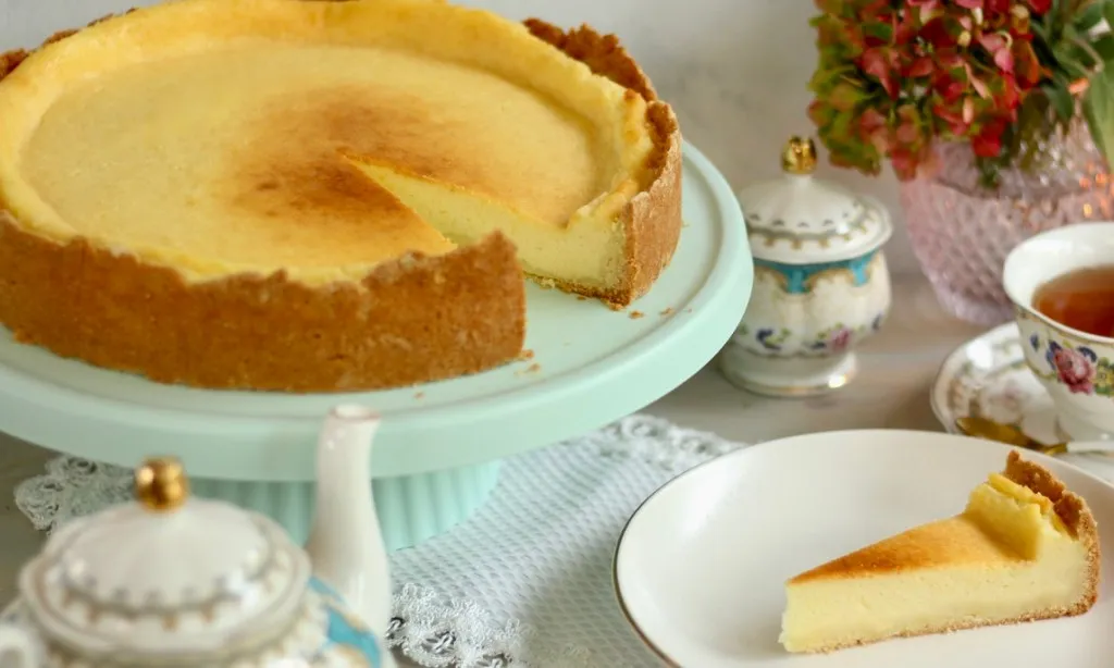 Ein fertig gebackener Käsekuchen auf einer Kuchenplatte