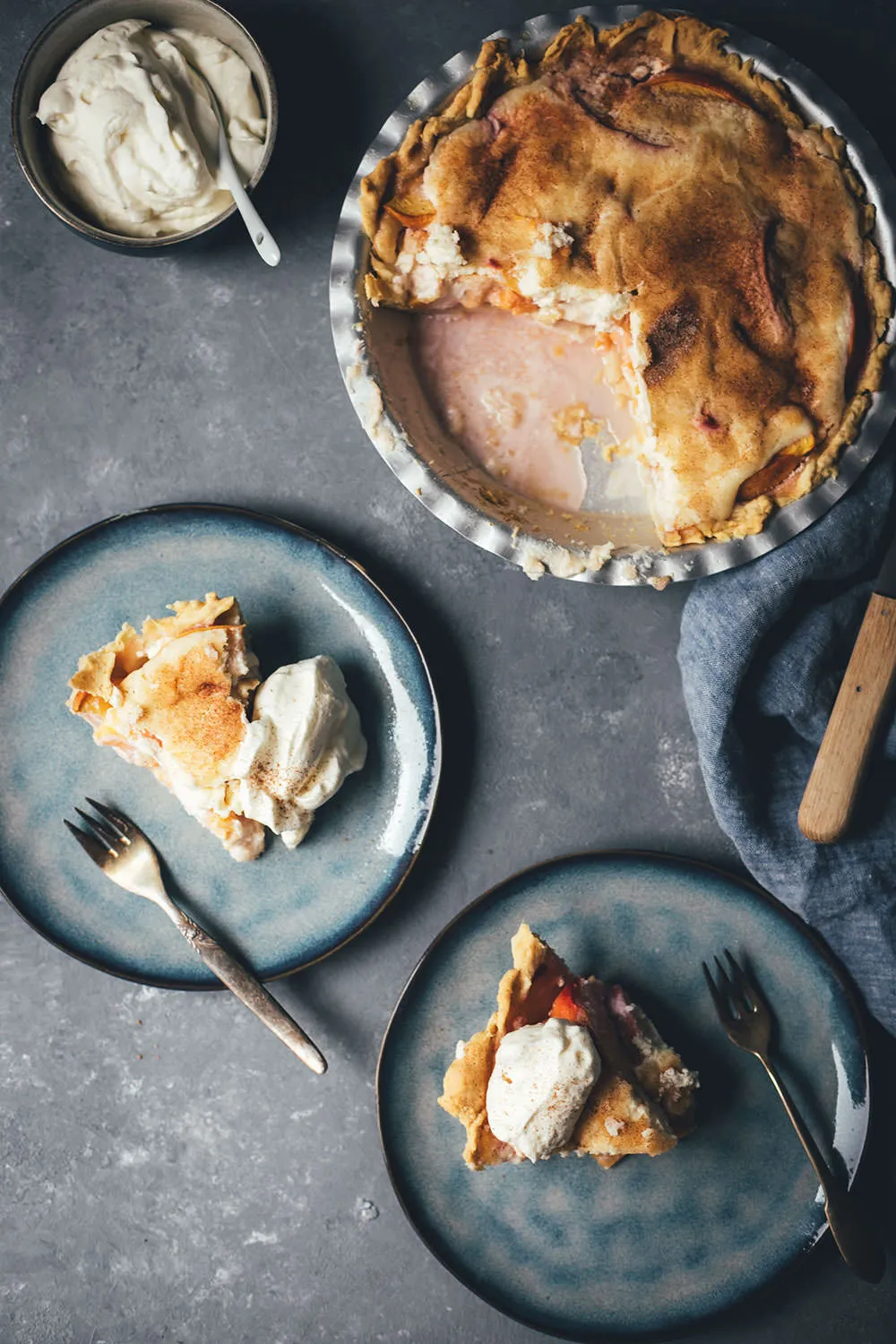 Ein fertig gebackener Peaches and Cream Pie mit Zimt bestreut, noch in der Auflaufform, bereit zum Abkühlen.