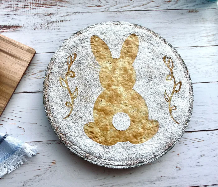 Ein festlich dekorierter Osterkuchen mit Hasenschablone und Puderzucker