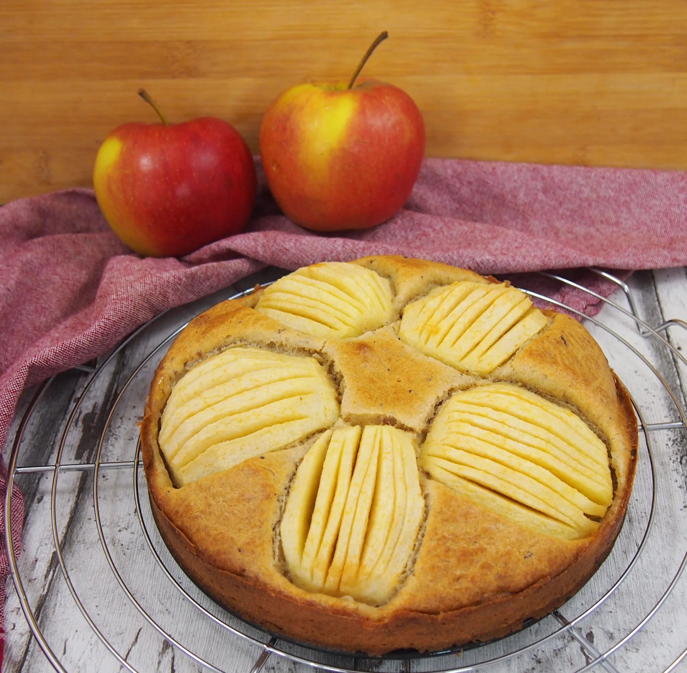 Ein frisch gebackener Apfelkuchen ohne Zucker mit Datteln und Dinkelmehl, appetitlich angerichtet auf einer Etagere.