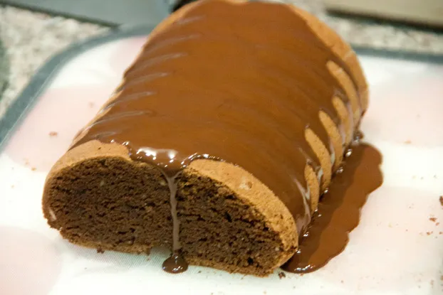 Ein frisch gebackener Rehrückenkuchen wird nach dem Backen auf ein Holzbrett gestürzt