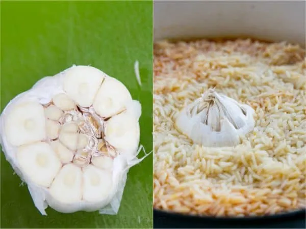 Ein ganzer Knoblauchkopf, unten angeschnitten, wird in die Mitte des Reises gedrückt und mit Koriander bestreut, um dem Plov zusätzliche Aromen zu verleihen