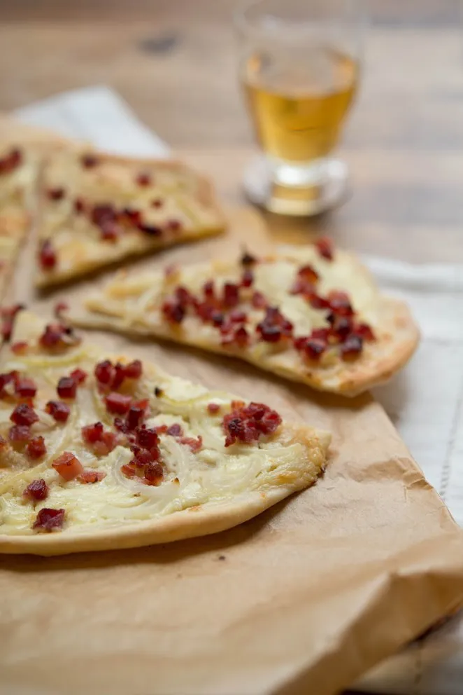 Ein ganzer, original belegter Flammkuchen mit Crème fraîche, Speck und Zwiebeln