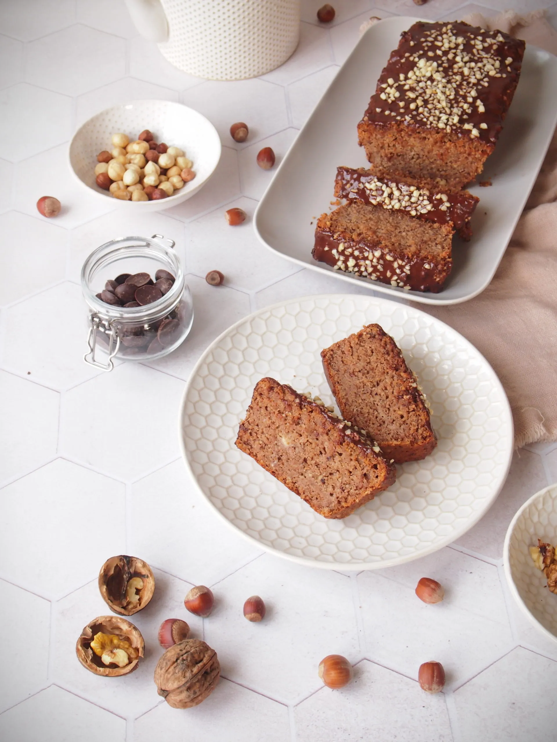 Ein ganzer veganer Nusskuchen, frisch gebacken und glasiert, in einer Kastenform