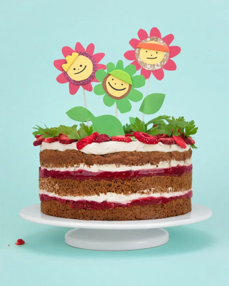 Ein ganzer zuckerfreier Geburtstagskuchen mit cremigem Frischkäse-Frosting, liebevoll dekoriert für ein Kleinkind.