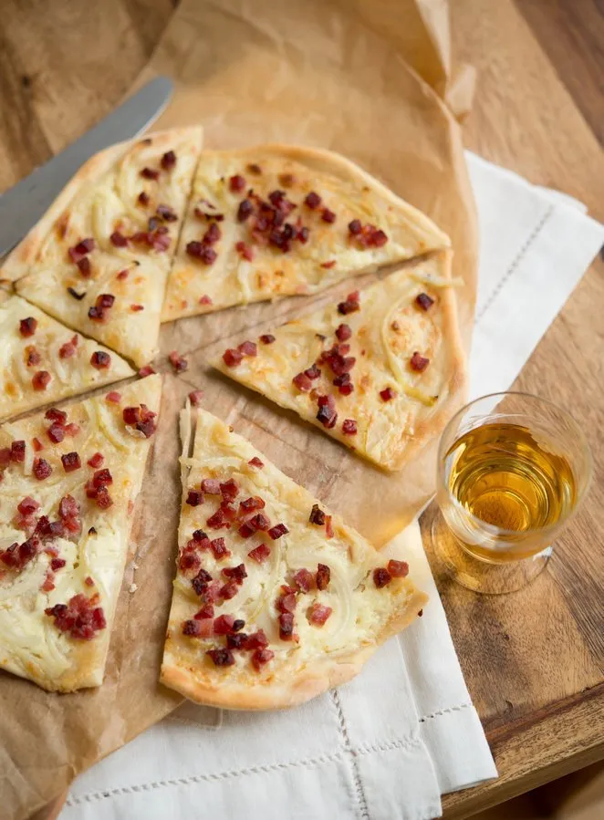 Ein gebackener Flammkuchen mit knusprigem Rand, schnell und einfach zubereitet