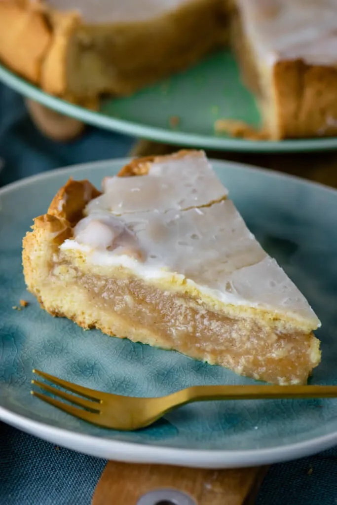 Ein gedeckter Apfelkuchen mit Apfelmus, bestrichen mit hellem Zuckerguss, bereit zum Servieren, Symbol für deutschen Herbstkuchen