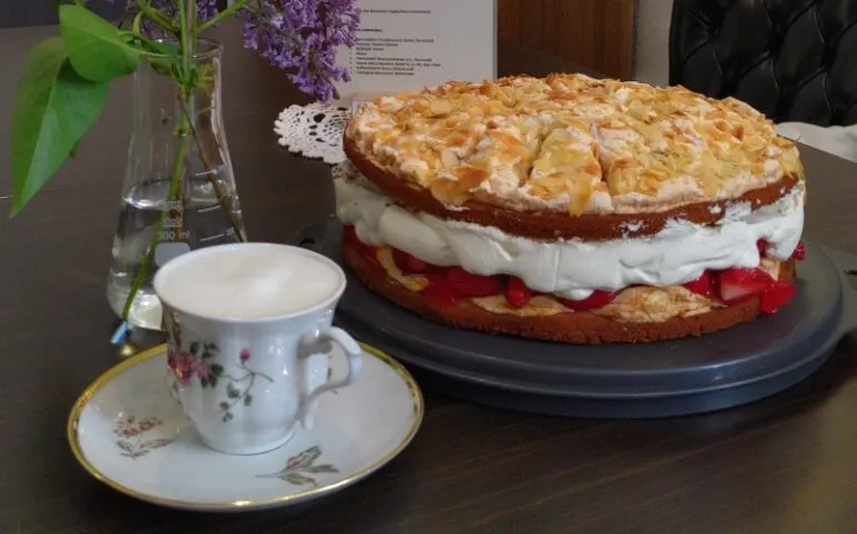Ein gedeckter Kaffeetisch mit zwei köstlichen Tortenstücken und Tassen im Café Kranich