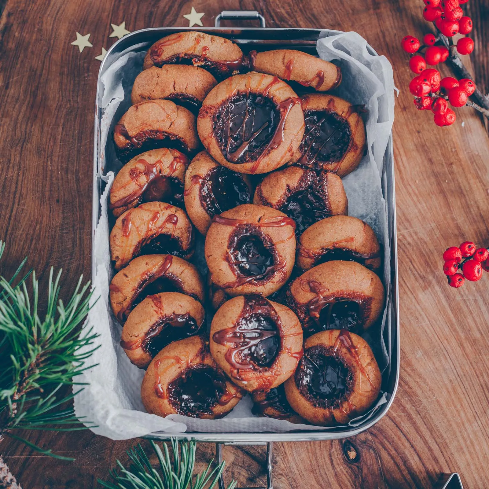 Ein gemütliches Arrangement von veganen Plätzchen auf einer Serviette, begleitet von einem Heißgetränk, das die festliche Stimmung einfängt