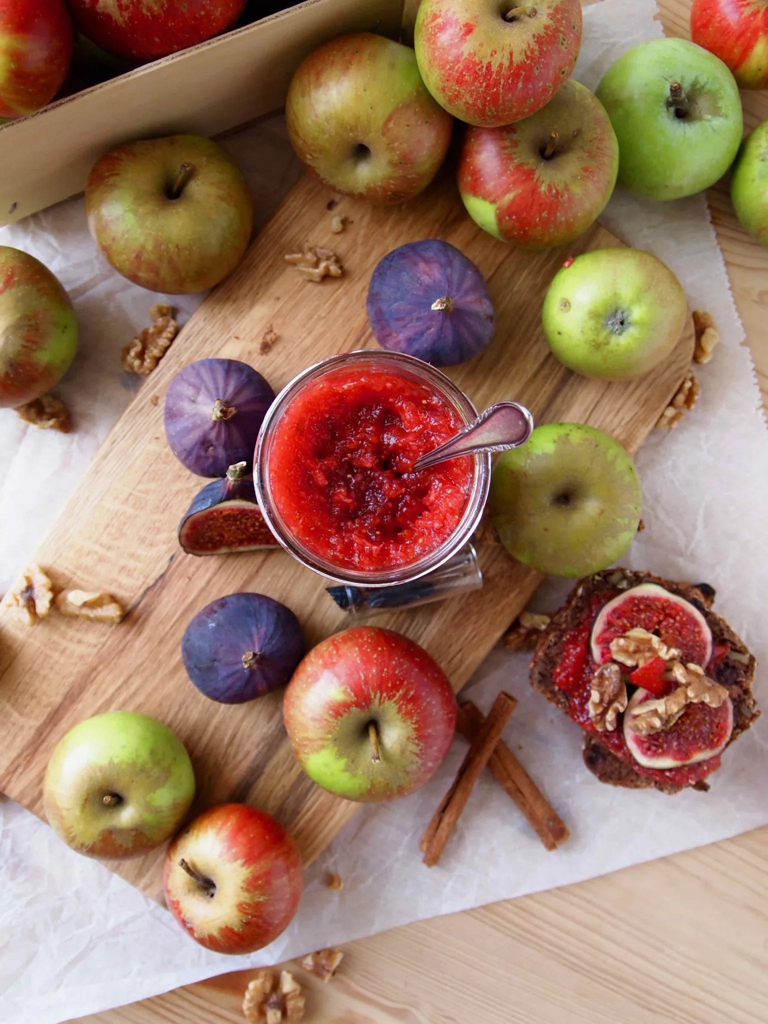 Ein geöffnetes Glas köstlicher Apfel-Feigen-Marmelade mit Tonkabohne und frischen Feigen als Dekoration
