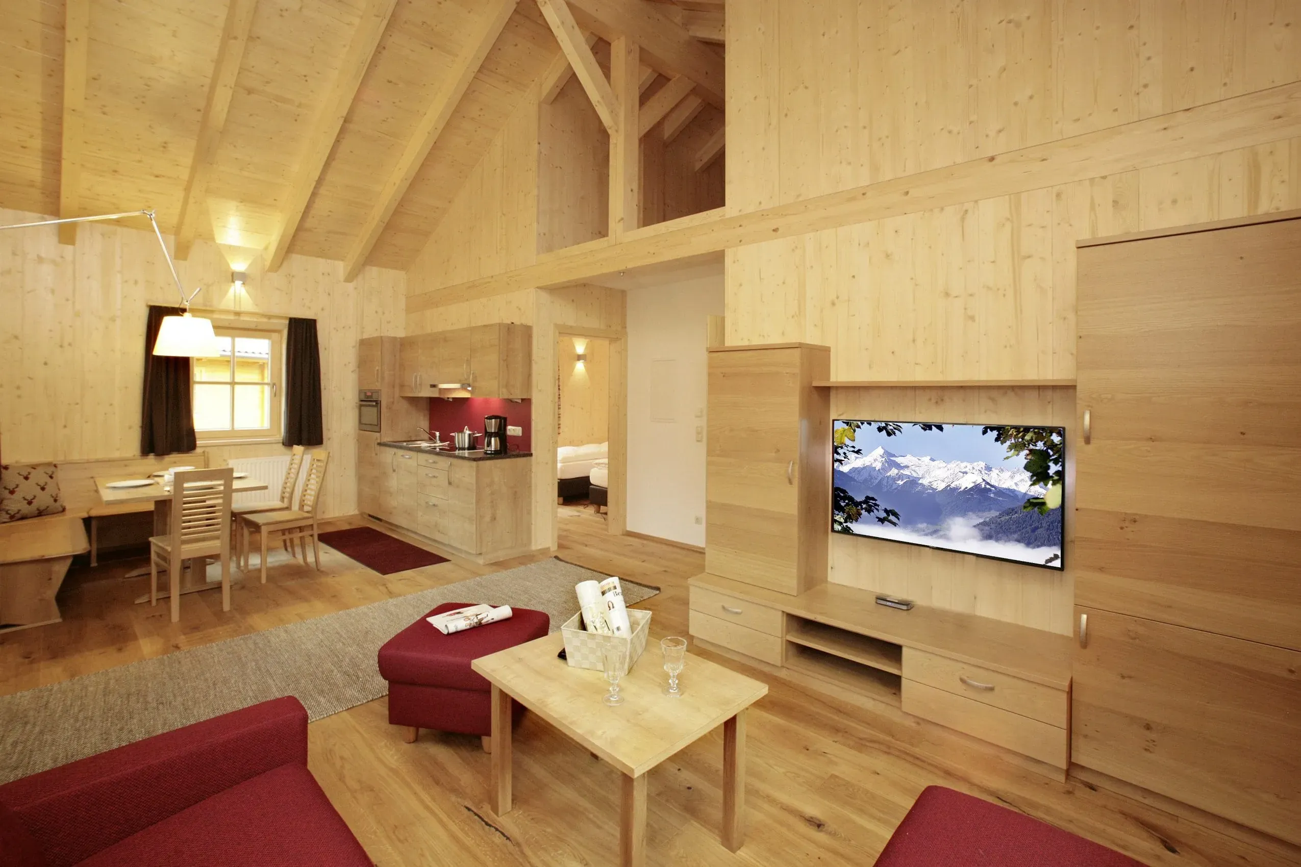 Ein geräumiger Wohnraum mit traditionellen Holzmöbeln in einem Chalet des Chaletdorf ZellerSee, ideal für einen komfortablen Urlaub mit Hund.