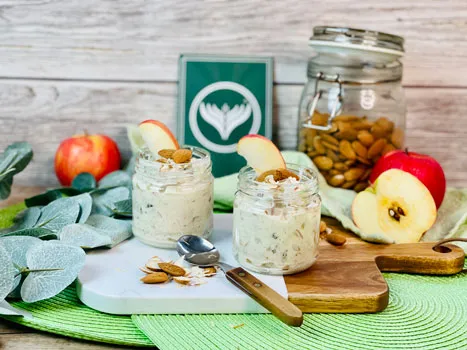 Ein Glas Bircher Müsli mit frischen Beeren, Haferflocken und Nüssen