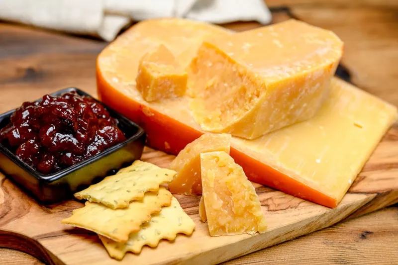 Ein Glas mit köstlichem Apfelchutney neben Käse und Crackern