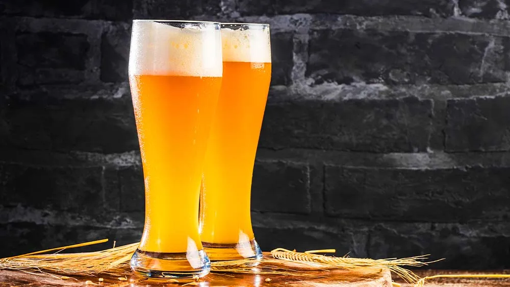 Ein Glas naturtrübes Weizenbier mit Schaumkrone