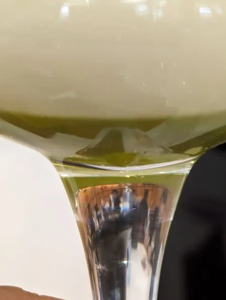 Ein Glas ungewöhnlich grün gefärbtes, alkoholfreies Bier mit Minzdekoration, das die Vielfalt und Experimentierfreudigkeit der alkoholfreien Bierszene in Deutschland und international illustriert.