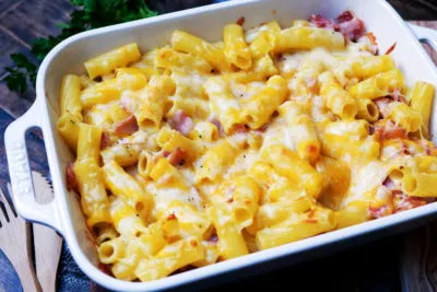 Ein goldbraun überbackener Nudel-Schinken-Auflauf frisch aus dem Ofen, in einer rechteckigen Auflaufform, bereit zum Servieren.