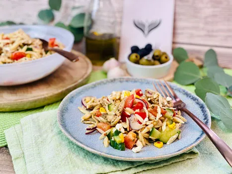 Ein griechischer Reisnudel-Gyrossalat mit frischem Gemüse und Tzatziki