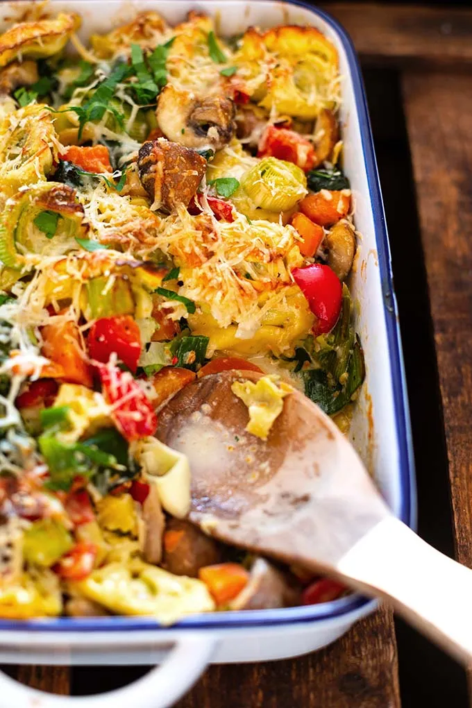 Ein großer Tortellini-Auflauf mit gemischtem Gemüse und cremiger Sauce, dampfend in einer Auflaufform.