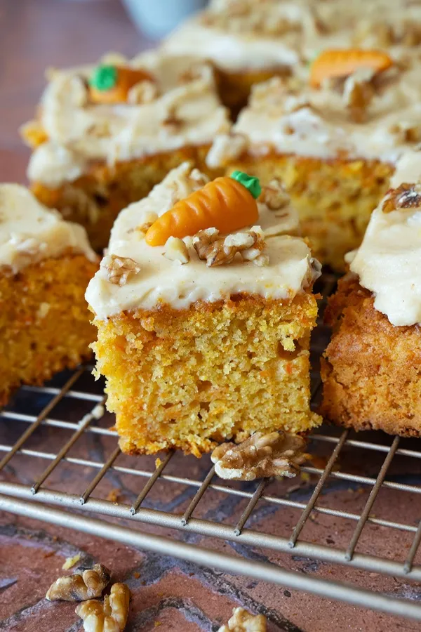 Ein großes Blech saftiger Rüblikuchen mit cremigem Frischkäse-Frosting, dekoriert für Ostern.