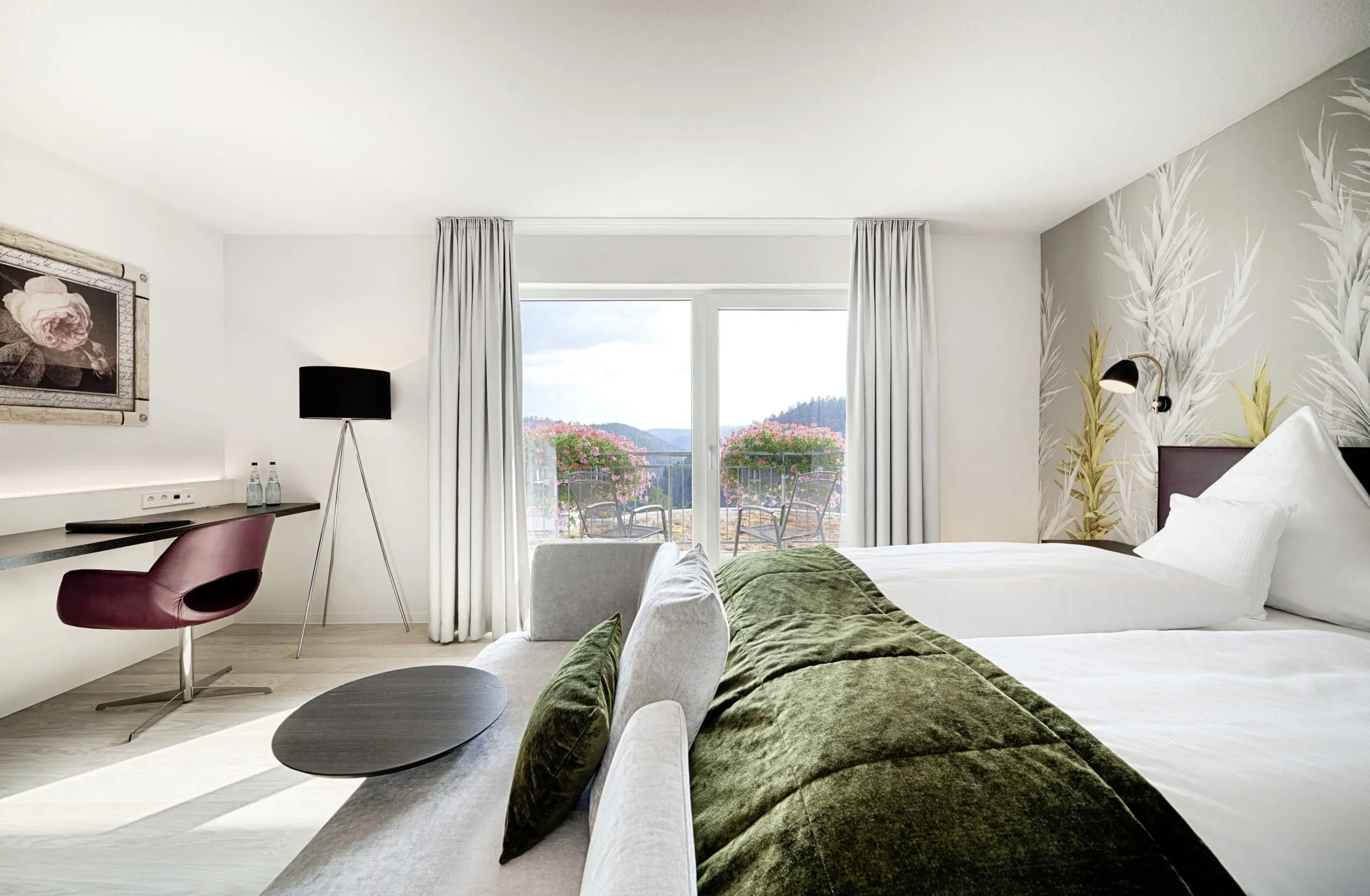 Ein helles Doppelzimmer im Hotel Kronelamm im Schwarzwald mit bodentiefen Fenstern, die einen wunderschönen Blick auf die Natur ermöglichen – perfekt für ein Hotel mit Hund.