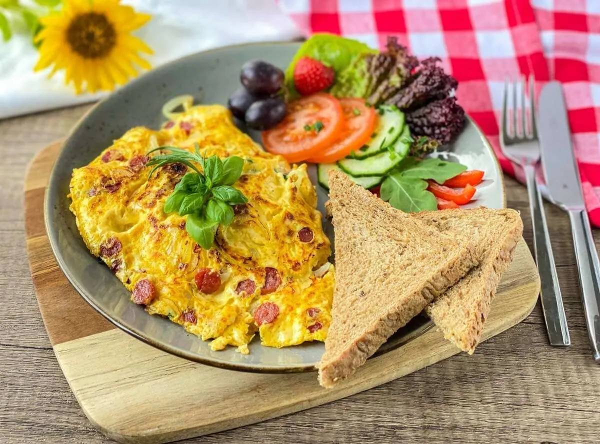 Ein herzhaftes Omelett mit Salami und Käse, serviert auf einem Teller mit frischem Salat.