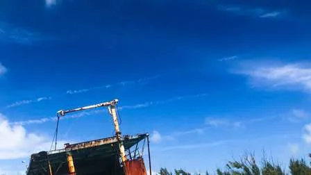 Ein idyllischer Strand der Turks- und Caicosinseln, mit einem Pier, klarem türkisfarbenem Wasser und einem weiten blauen Himmel.