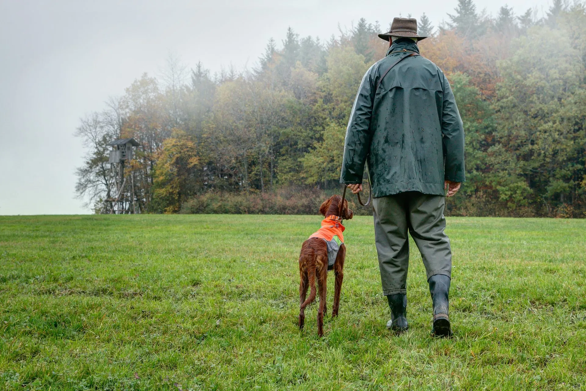 Ein Jäger spaziert mit seinem Hund.