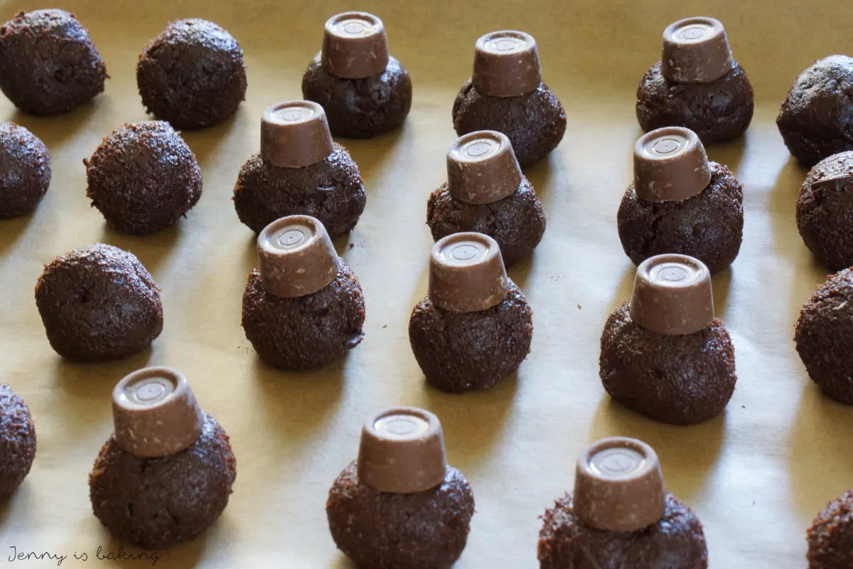 Ein Karamellbonbon wird zwischen zwei kleinen Schoko Teigkugeln platziert