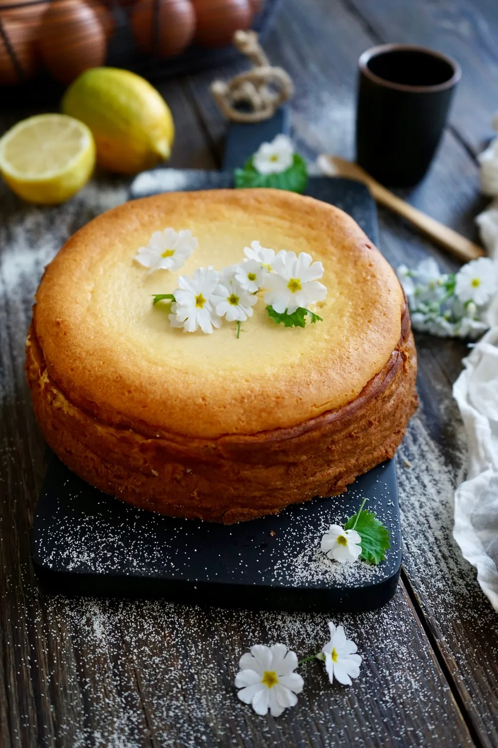 Ein kleiner, goldbraun gebackener Käsekuchen ohne Boden, fertig zum Genießen, auf einem Holzbrett angerichtet.