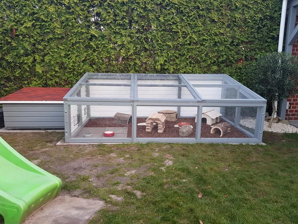 Ein kniehohes, mardersicheres Außengehege für Meerschweinchen mit Gittern und Holzrahmen