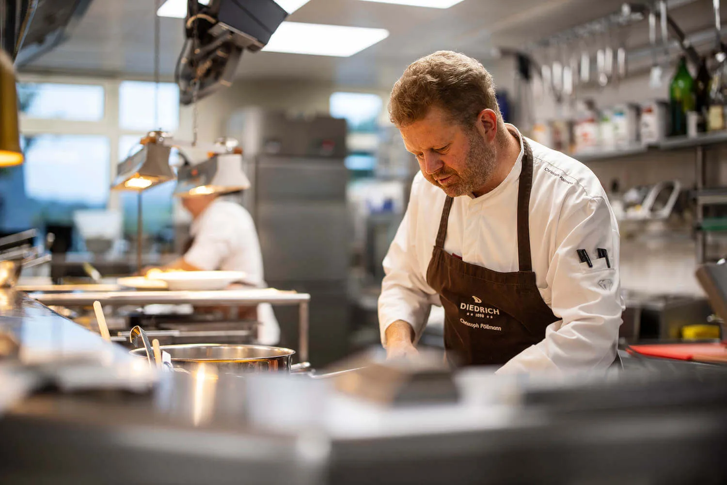 Ein Koch und eine Köchin beim Kochen in der Küche - Hotel Diedrich