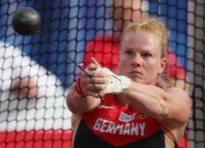 Ein Leichtathlet demonstriert den Griff und die Form des Hammers für den Hammerwurf