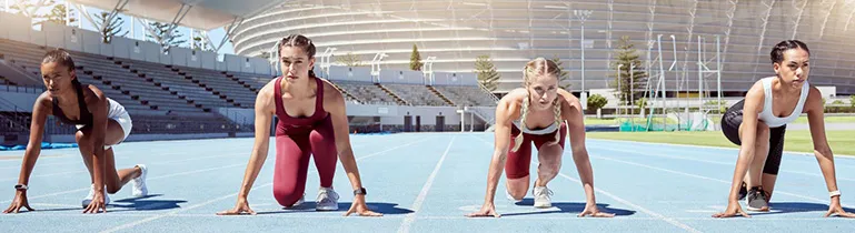 Ein Leichtathlet springt über eine Hürde auf einer Laufbahn, symbolisierend Dynamik und Geschicklichkeit.