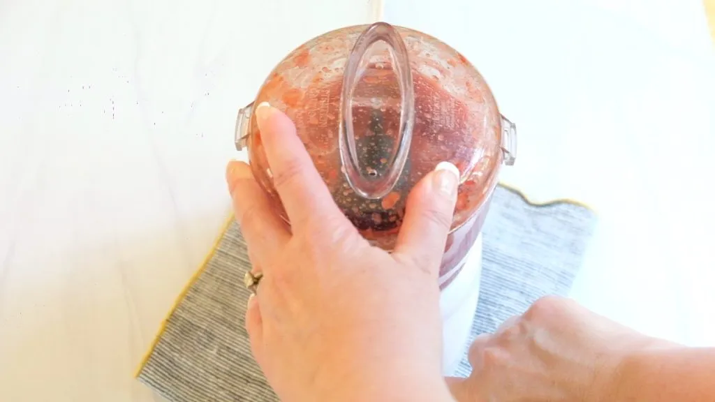 Ein Löffel rührt die frisch pürierte Erdbeersauce in einer Schüssel