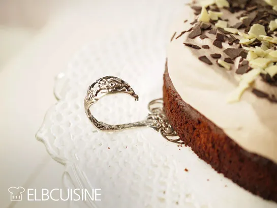 Ein Löffel taucht in die cremige Schoko Sahne Torte ein, die perfekte Konsistenz für Genussmomente.