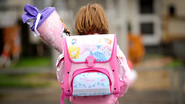 Ein Mädchen mit Ranzen und Schultüte am Einschulungstag in Deutschland
