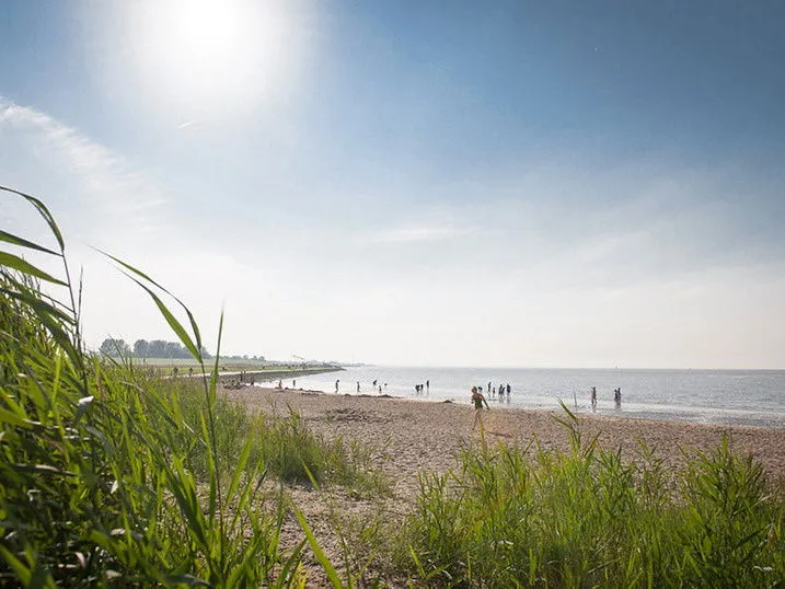 Ein modernes Hotelgebäude mit einem blauen Logo an der Nordseeküste in Otterndorf, das auf einen entspannten Kurzurlaub hinweist