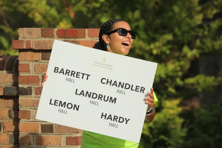 Ein Orientierungshelfer heißt neue Studierende auf dem Campus willkommen.