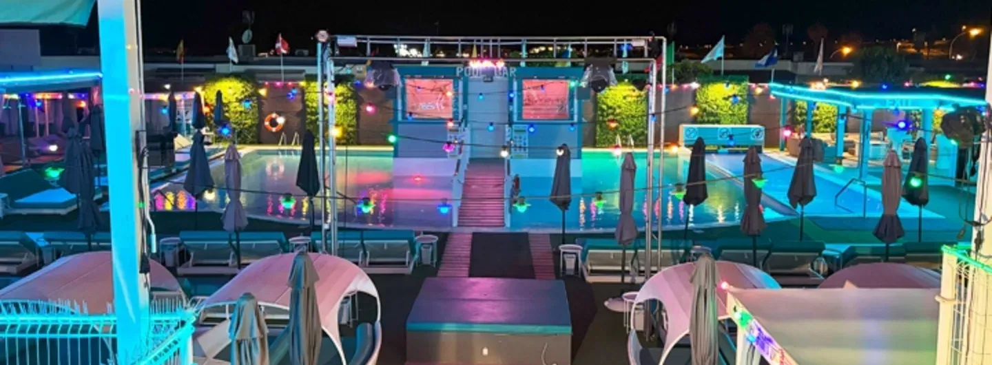 Ein Paar entspannt am Pool eines Swinger Resorts