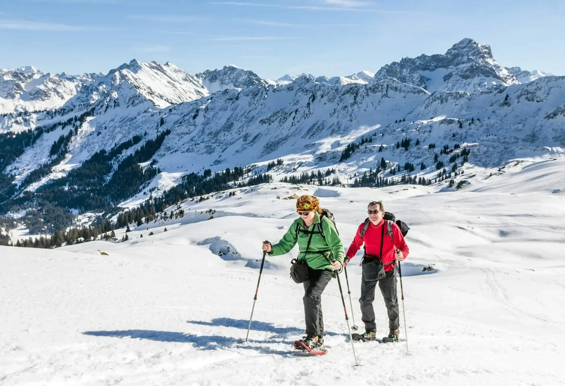 Ein Paar wandert durch eine verschneite Landschaft in den Allgäuer Bergen