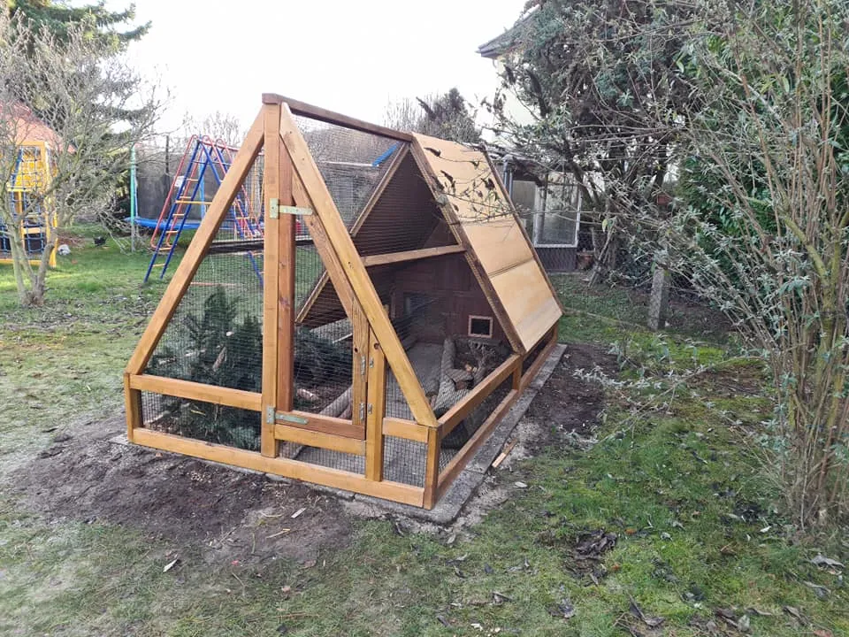 Ein Pyramidengehege für Meerschweinchen im Garten mit schräger Dachkonstruktion