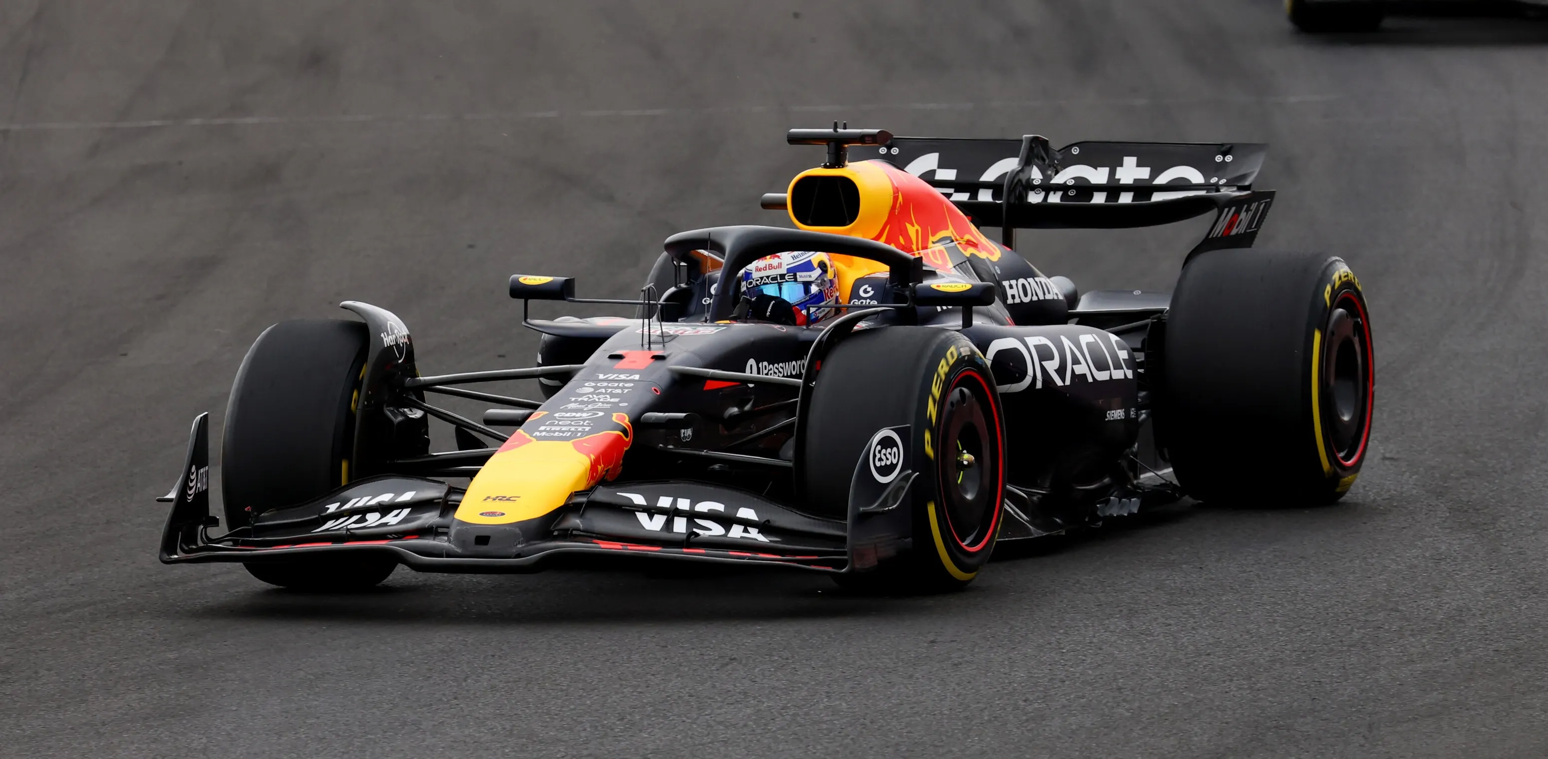 Ein Rennauto der Formel 1 in voller Fahrt auf der Strecke, mit unscharfem Hintergrund.