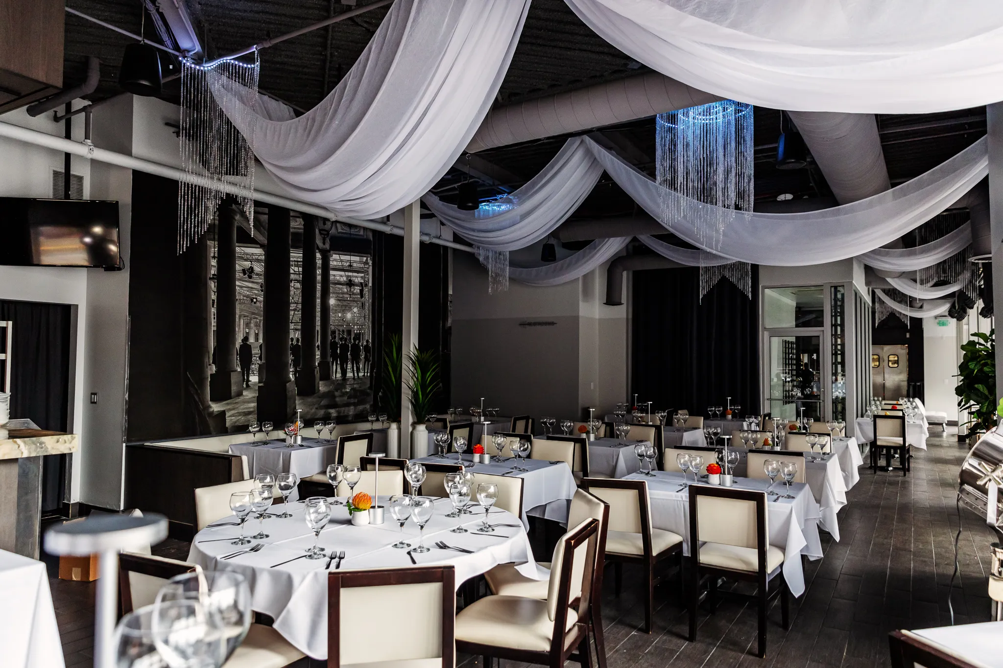 Ein Restaurant-Speisesaal voller weißer Tische und Stühle.