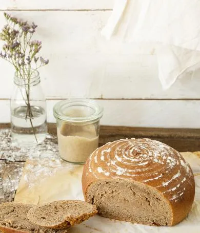 Ein Roggenbrot mit Sauerteig, das frisch aus dem Ofen kommt und auf einem Rost abkühlt