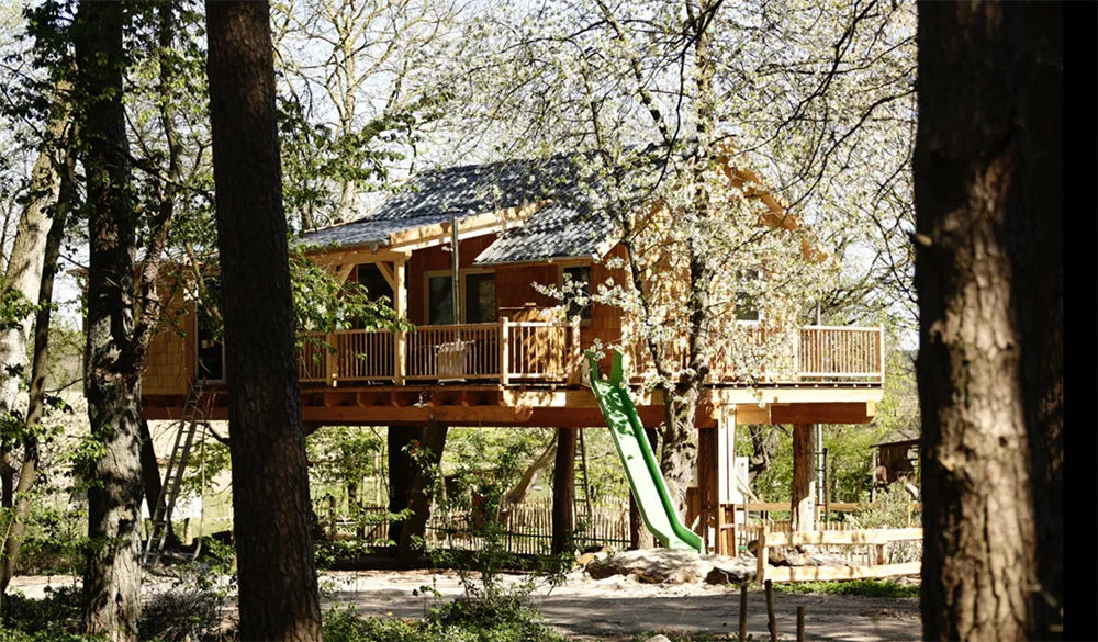 Ein rustikales Baumhaus, das sich harmonisch in die Baumkronen einfügt, mit einer Holzkonstruktion und einem gemütlichen Ambiente.