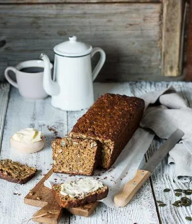 Ein rustikales Sauerteigbrot, aufgeschnitten und mit Butter bestrichen