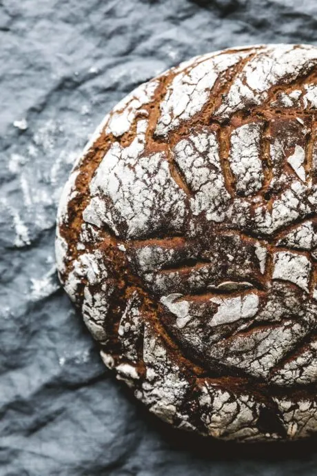 Ein rustikales Sauerteigbrot, das gerade angeschnitten wird und eine saftige Krume offenbart.