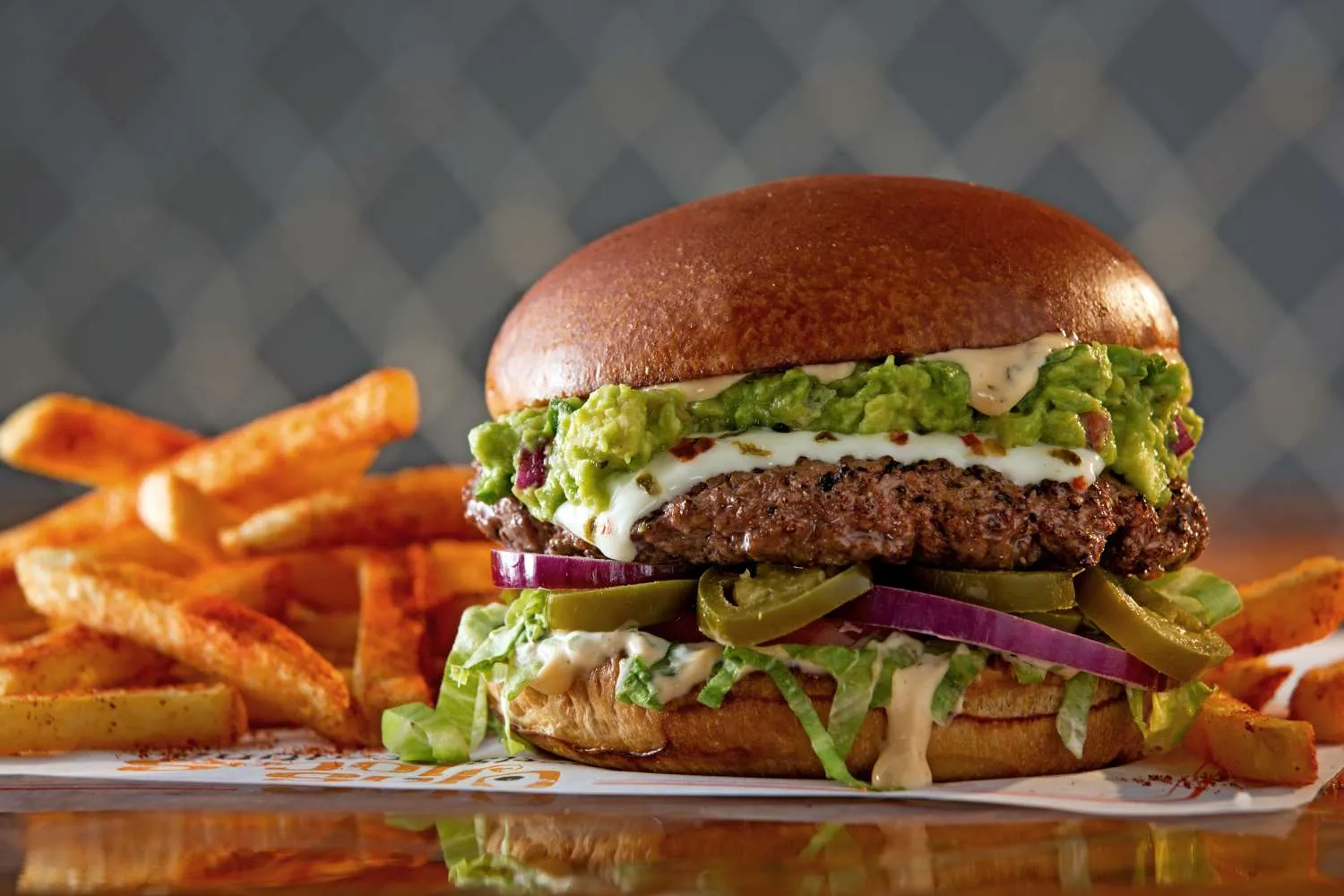 Ein saftiger Yucatán Burger, ein Highlight des Ojos Locos Menüs in einer Sports Cantina Umgebung.